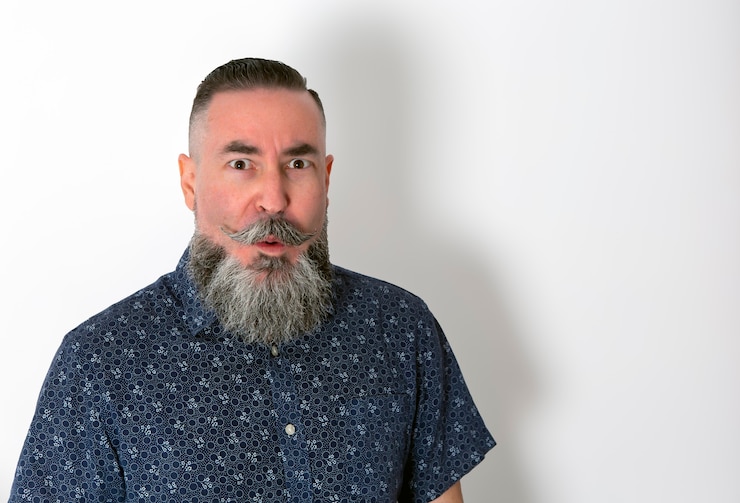 Foto hipster con camisa de flores gran barba y bigote de cerca con cara de sorpresa en blanco