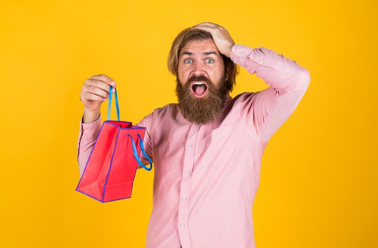 Foto hipster caucasiano brutal com presente. macho vai às compras com a compra. viciado em compras de sucesso. homem barbudo pronto para férias. venda e desconto. hipster maduro com barba segura pacote de presentes. ah não.