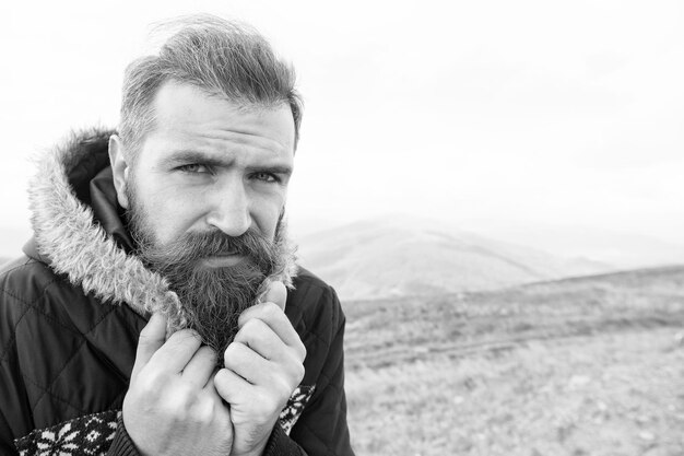 Hipster caucasiano brutal de homem barbudo com bigode frio na montanha