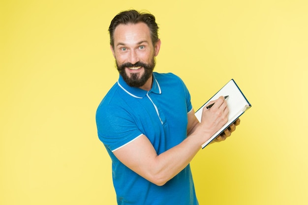 Hipster caucásico brutal con bigote. Hipster maduro con barba. Hombre barbudo. Cuidado del peluquero masculino. hombre feliz con cuaderno y bolígrafo. Centrarse en el trabajo. Analizando estrategia.