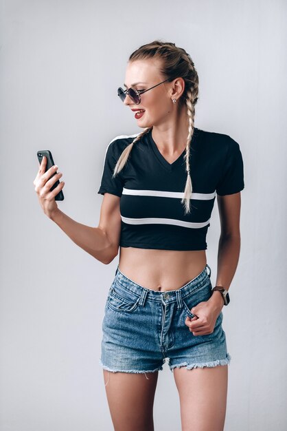 Hipster chica con gafas de sol con teléfono