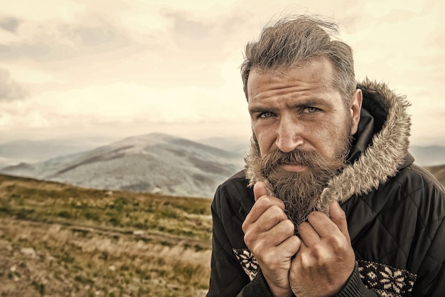 Foto hipster com cara séria nas montanhas