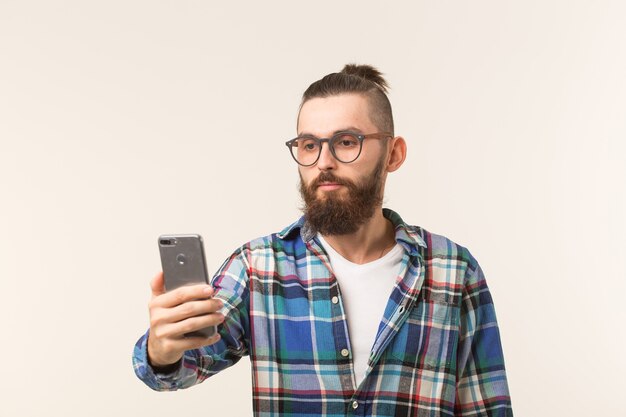 Hipster, conceito de pessoas - jovem hippie com barba em copos tomando selfie