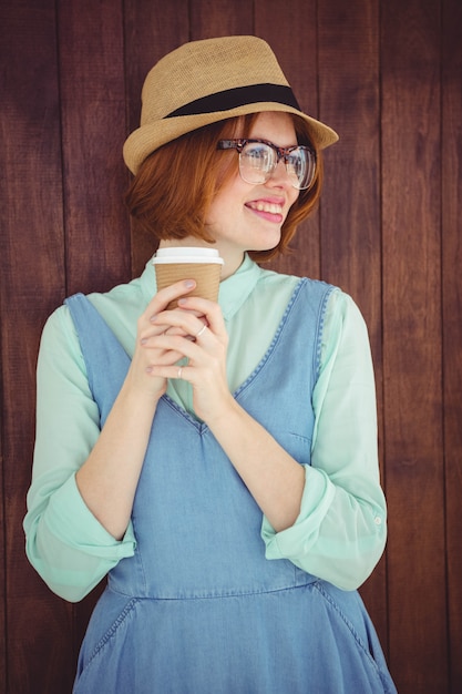 Foto hipster de cabelo vermelho bonito com óculos segurando copo descartável