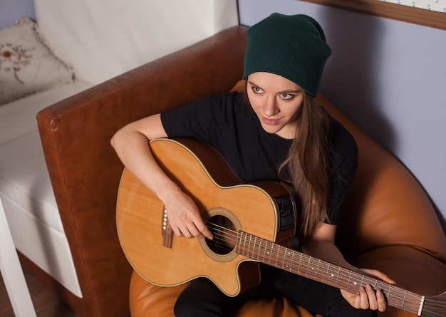 Hipster de mulher tocando violão e cantando