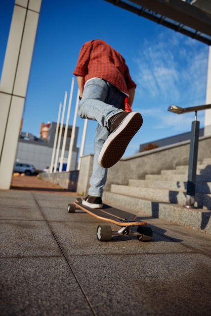 Hipster, der auf einer Stadtstraße Skateboard fährt