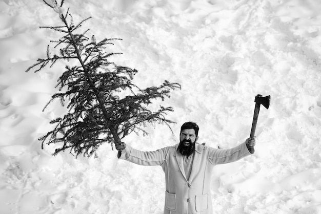 Hipster emocionado con una larga barba sosteniendo un árbol y un hacha