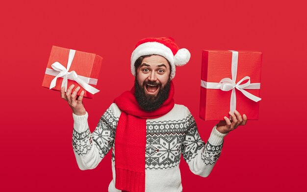 Hipster emocionado mostrando regalos de Navidad