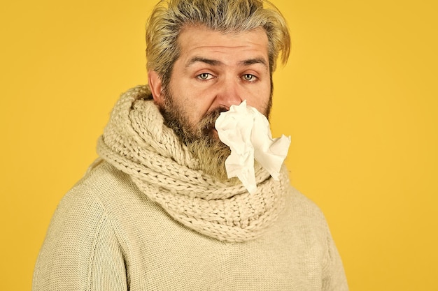 Hipster espirrando e assoando o nariz Reação alérgica processo inflamatório homem doente tem sintomas de gripe nasal e infecção por vírus coronavírus da china imunidade contra portador de vírus epidêmico