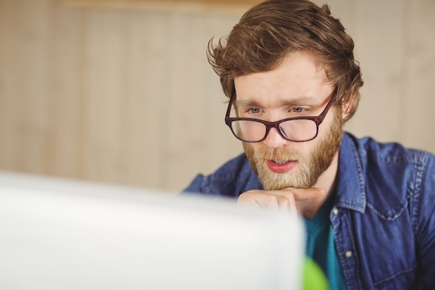 Foto hipster focado trabalhando em sua mesa