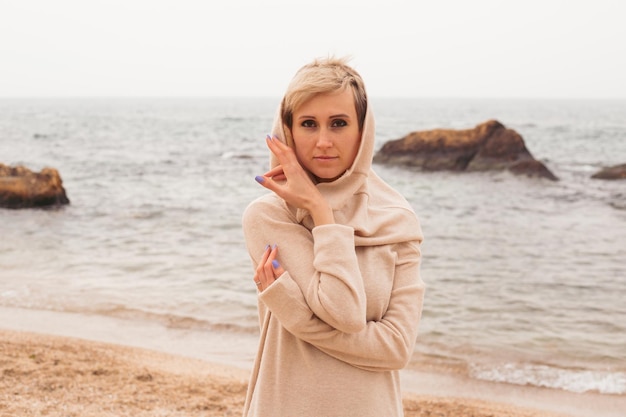 Hipster-Frau mit Kleid in der Nähe des Meeres im Herbst