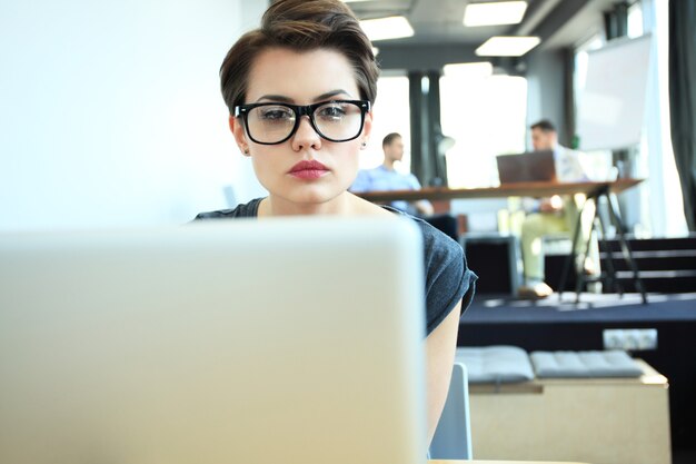 Hipster Frau verwenden Laptop riesigen Loft Studio.Student Forschungsprozess Arbeit.Junge Business Team Arbeiten Kreatives Startup modernes Büro.Analyse Marktbestand, neue Strategie.B verschwommen, Filmeffekt.