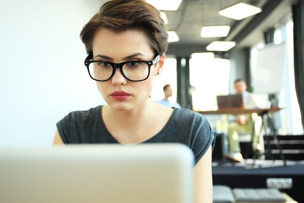 Hipster Frau verwenden Laptop riesigen Loft Studio.Student Forschungsprozess Arbeit.Junge Business Team Arbeiten Kreatives Startup modernes Büro.Analyse Marktbestand, neue Strategie.B verschwommen, Filmeffekt.