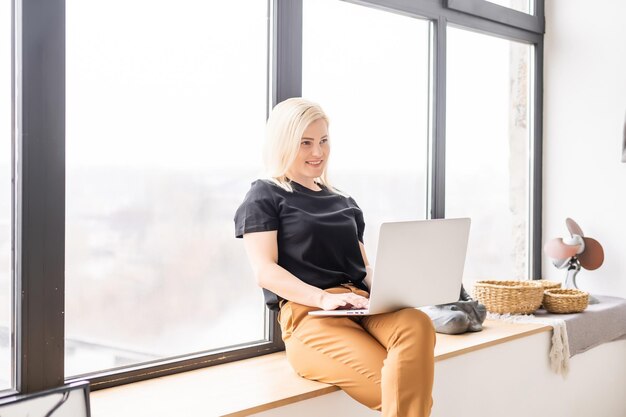 Hipster-Frau verwendet Laptop riesiges Loft-Studio. Studentische Forschung zur Prozessarbeit. Junge Geschäftsfrau, die kreatives Startup-modernes Büro arbeitet. Marktbestand analysieren, neue Strategie.