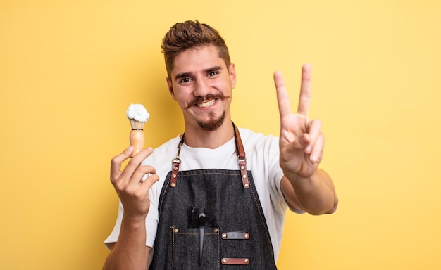 Hipster-Friseurmann lächelt und sieht freundlich aus und zeigt Nummer zwei