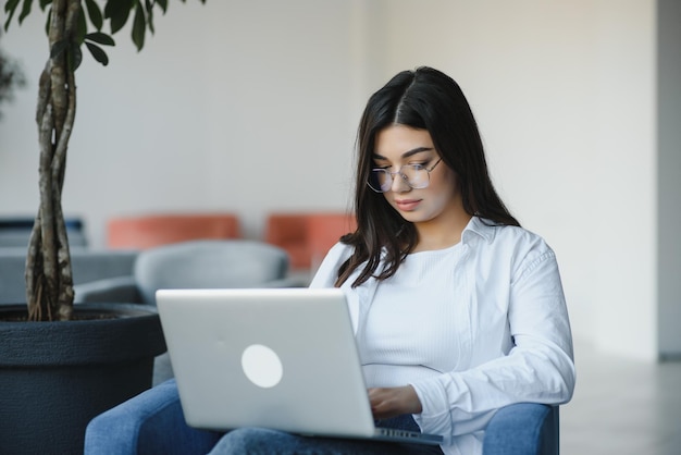 Hipster Girl use Laptop enorme Loft StudioStudent Researching Process WorkYoung Business Woman Working Creative Startup modern OfficeAnalyze market stocknew estrategia