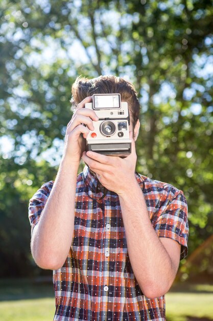 Hipster guapo con cámara vintage