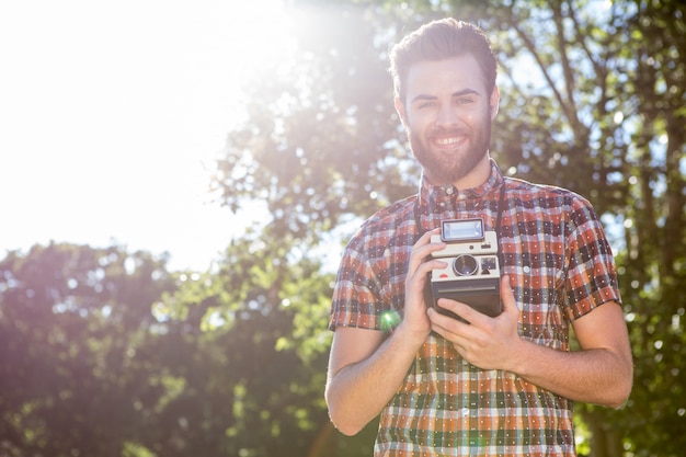 Hipster guapo con cámara vintage