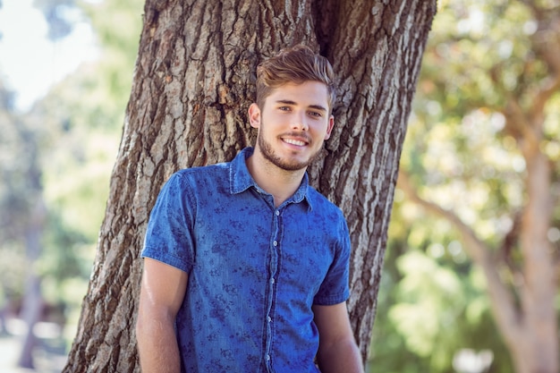 Hipster guapo sonriendo en el parque