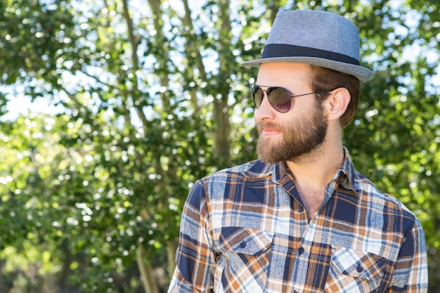 Hipster guapo sonriendo en el parque