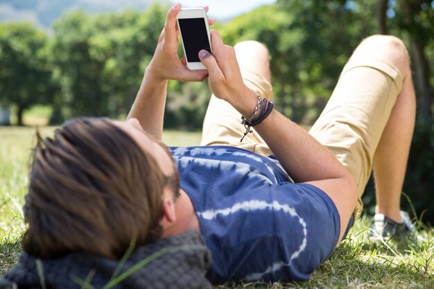 Hipster guapo con teléfono en el parque