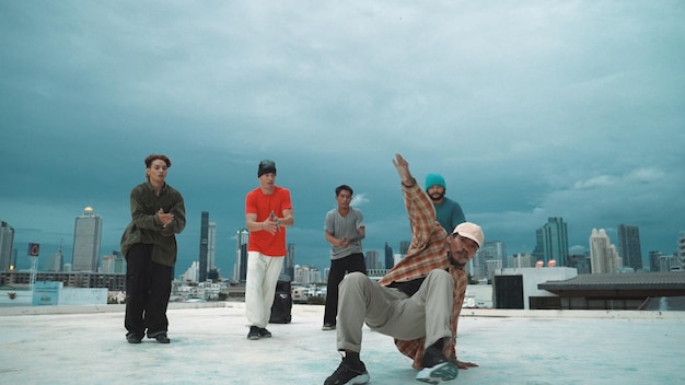 Foto hipster hispano bailando rodeado de amigos multiculturales en el esfuerzo de la ciudad