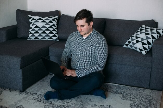 Hipster hombre trabajando en casa en la computadora