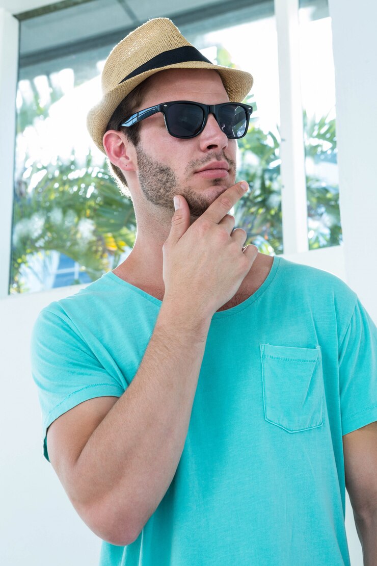 Foto hipster homem posando com óculos de sol em casa