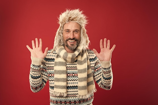 Hipster ist immer Hipster Mann bärtiger Hipster trägt pelzigen Hut gestreiften Schal und Strickpullover Hipster Mode Winter Accessoires Reifer Typ mit Bart und Schnurrbart trägt gerne ungewöhnliche Dinge