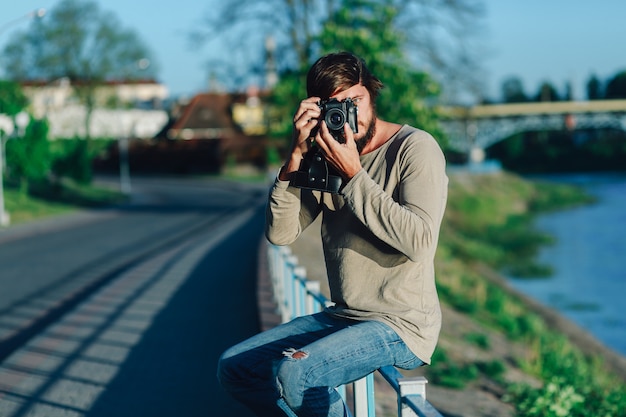 Hipster joven disparó fotografía de él cámara de cine en la calle pública