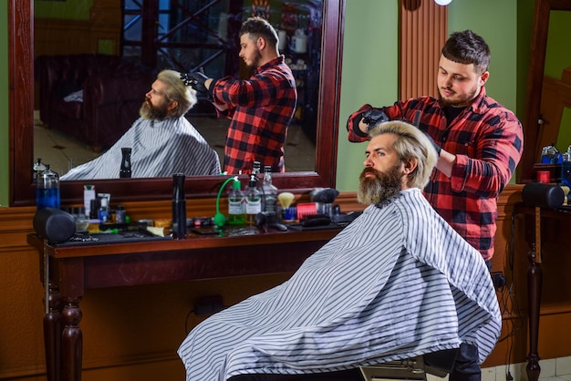 Hipster lässt sich die Haare schneiden Mann mit gefärbten Haaren Friseur Frisur Friseurladen Friseur Kosmetik Friseurwerkzeuge Friseur beschäftigt sich mit dem Prozess Haare stylen Nahezu unmöglich, den Vorgang zu ändern