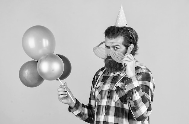 Hipster masculino com cabelo e barba arrumados na moda segura festa de balões de festa