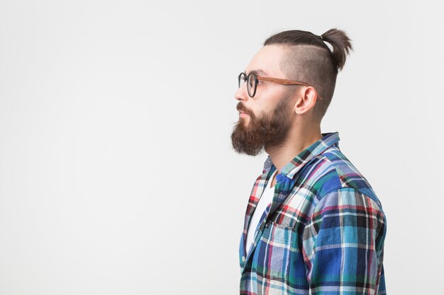 Hipster, moda, concepto de personas. joven inconformista barbudo con gafas y camisa de pie sobre el