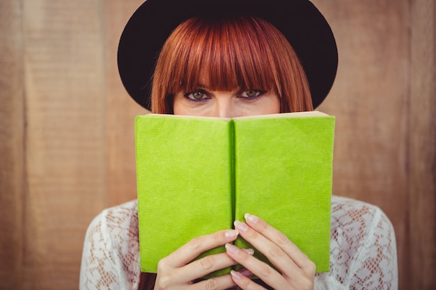 Hipster mujer detrás de un libro