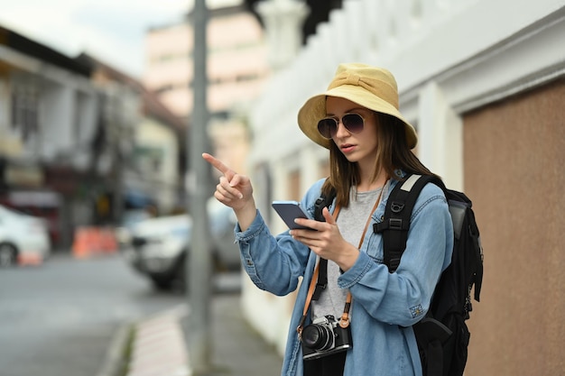 Hipster mujer viajera buscando dirección en el teléfono inteligente La gente de la vida viaja y el concepto de tecnología