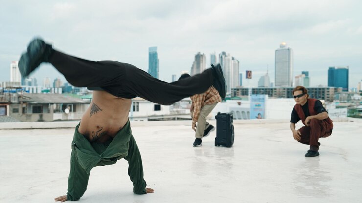 Foto hipster multicultural praticando dança bboy no telhado com vista para a cidade hiphop
