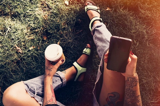 hipster, niña, sentado, en el estacionamiento, con, teléfono inteligente, y, café