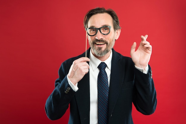 Hipster o nerd El hombre sostiene anteojos de accesorios de fiesta El jefe o el hombre de negocios visten traje formal posando accesorio de fiesta Estrategia de negocios Invitación de fiesta de negocios Conferencia de negocios y entretenimiento