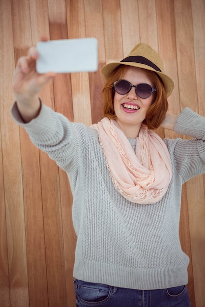 Foto hipster de pelo rojo tomando selfie