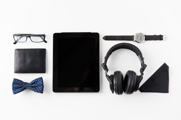 hipster persönliches zeug- und objektkonzept - tablet-pc-computer, kopfhörer, brieftasche, brille und armbanduhr auf dem tisch