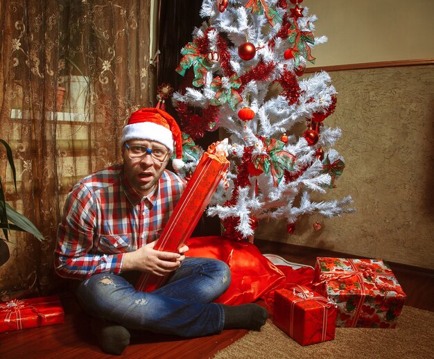 Foto hipster surpreso com muitos presentes de natal. ano novo.