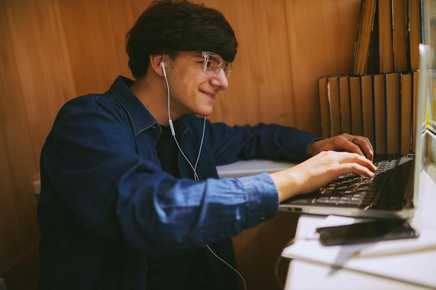 Hipster-Typ mit Brille, der sich ein Schulungs-Webinar auf einem Laptop ansieht Online-Schulung für Fernunterricht