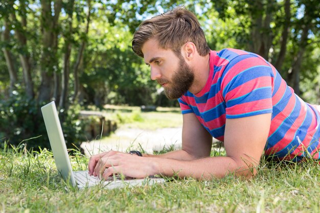 Hipster usando la computadora portátil en el parque