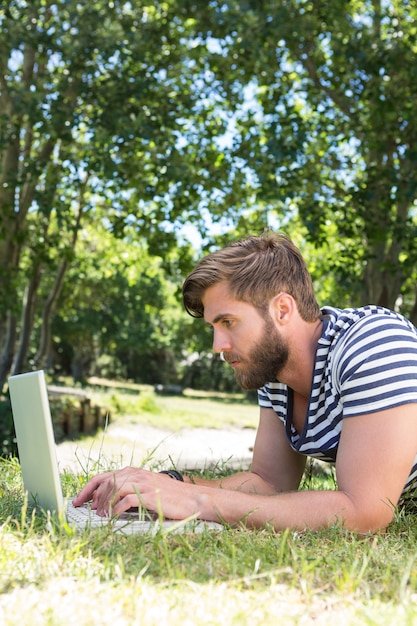 Hipster usando la computadora portátil en el parque