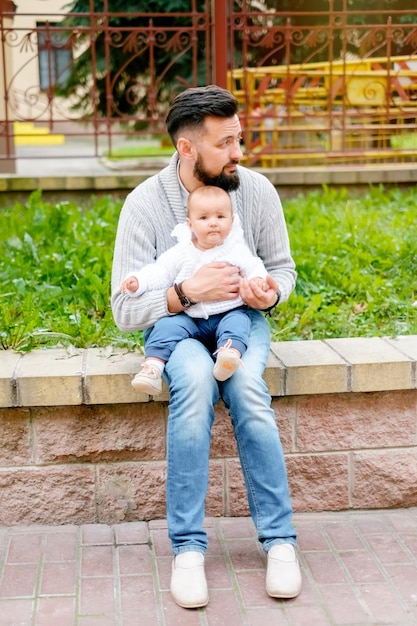 Hipster-Vater mit Baby Familienporträt in der Stadt Vater mit einem Kind für einen Spaziergang