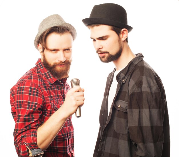 Foto hipster zwei junge männer singen mit mikrofon, isoliert auf weiss