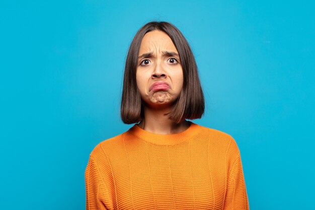 Hispanic Frau fühlt sich traurig und gestresst, verärgert wegen einer schlechten Überraschung, mit einem negativen, ängstlichen Blick