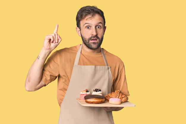 Hispanic männlicher Bäcker mit Gebäck mit einer großartigen Idee Konzept der Kreativität