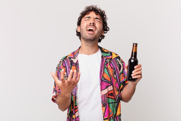 Hispanic Mann mit Bier, das verzweifelt und frustriert, gestresst, unglücklich und genervt aussieht, schreit und schreit