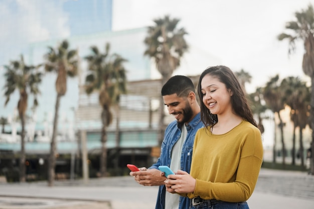 Hispânicos usando celular ao ar livre na cidade